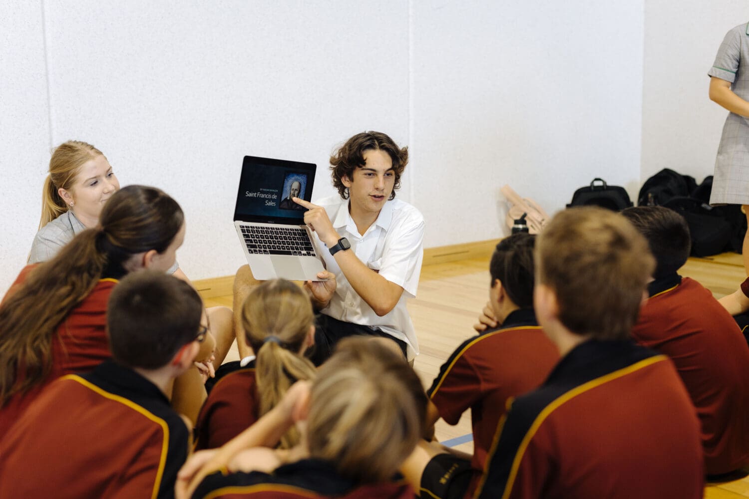 XCGB_Year 6 Transition-20 A male student leader giving an informative presentation to primary school students.